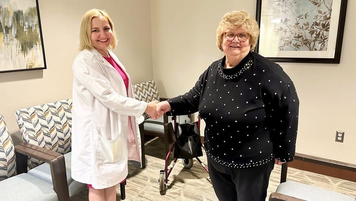 Staff member shaking hands with a resident in a lounge area