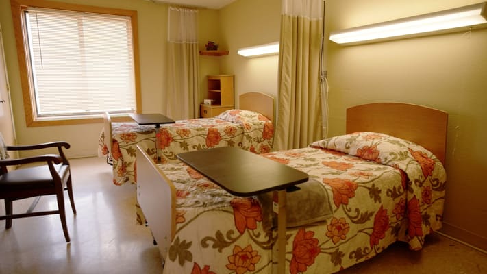 A cozy resident room with two beds and floral bedding