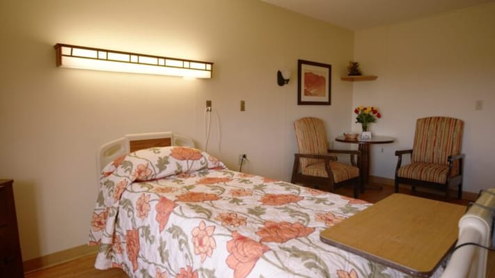 Cozy resident room with floral bedding and seating area