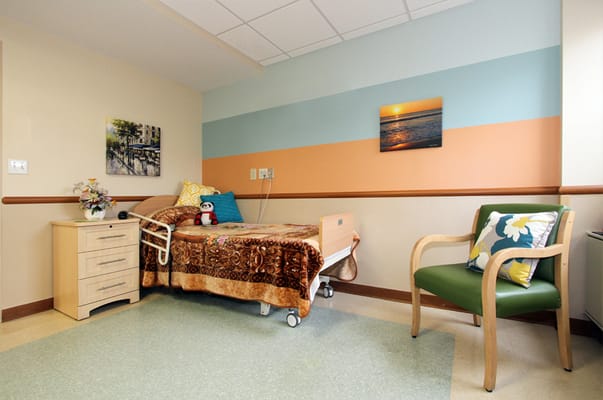 A resident room with a bed and chair