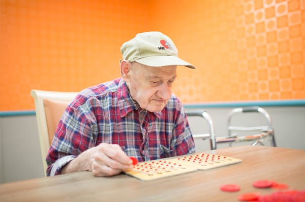 Resident playing bingo in a bright activity room