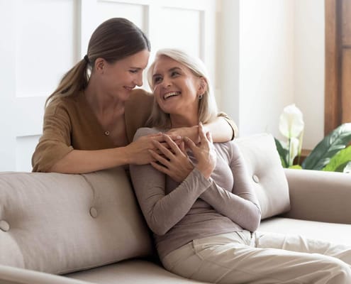 Two women enjoying time together on a sofa