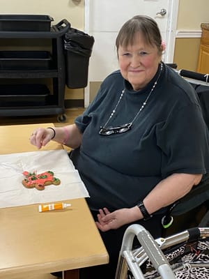 A resident decorating a cookie in a common area