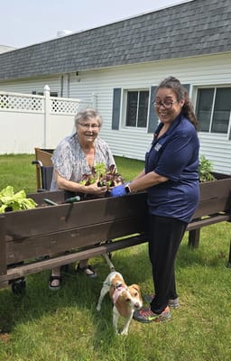 Residents gardening in the outdoor space with a staff member