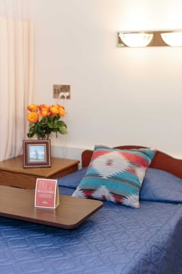 A cozy resident room with a welcome sign and flowers