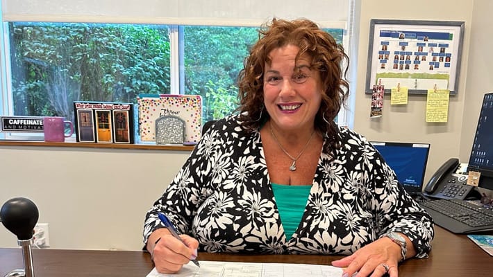 Staff member smiling at her desk in an office