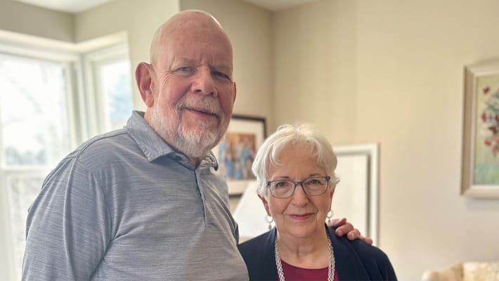 Two residents posing together in a cozy room