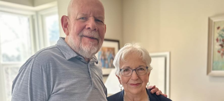 Two smiling residents posing together in a bright interior space