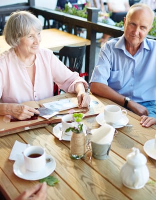 Two seniors enjoying coffee at a table
