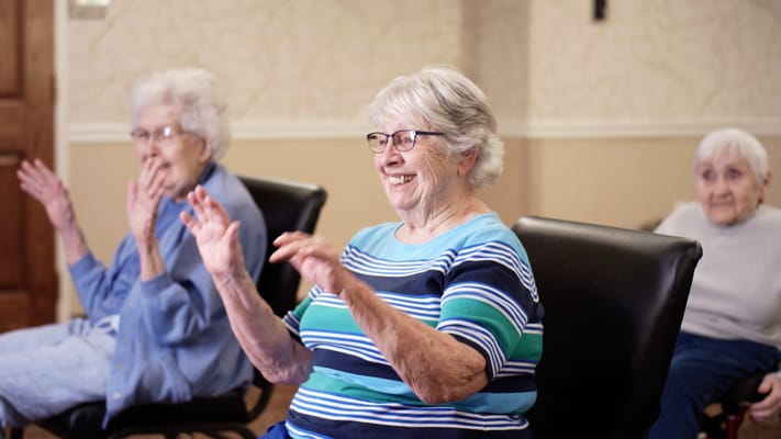 Residents participating in a seated activity in a common area