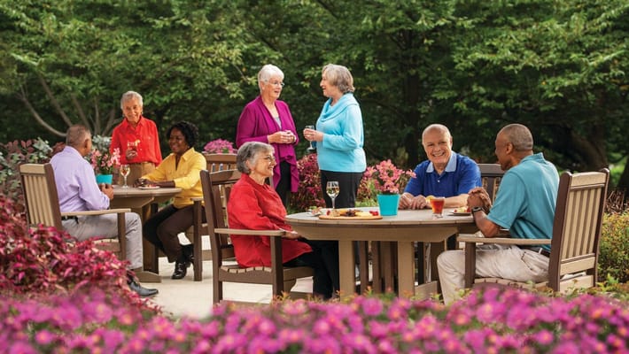 Residents enjoying outdoor dining in a garden area