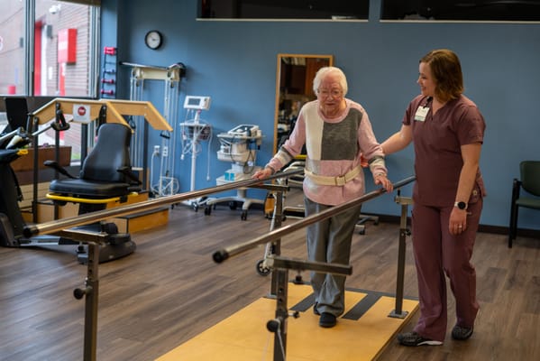 Resident assisted by staff during therapy session