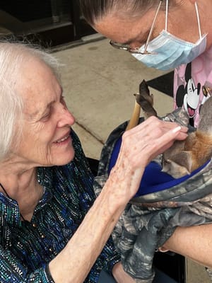 Resident interacting with a therapy animal outdoors