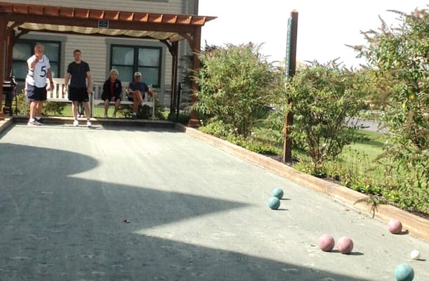 Residents playing bocce ball in an outdoor area
