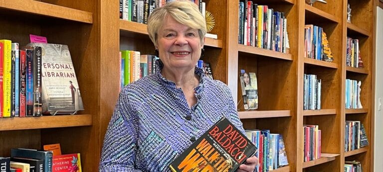 Resident holding a book in a library area
