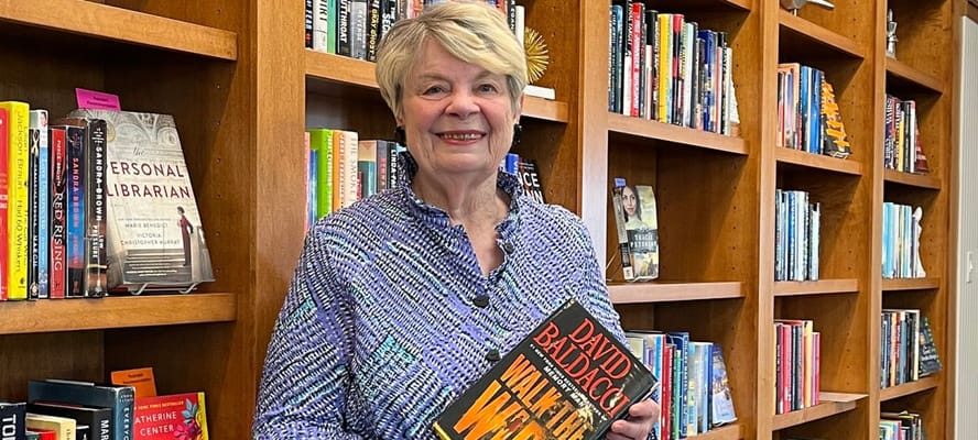 Resident holding a book in a library area