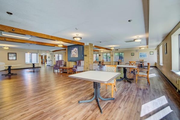 Common area with tables and chairs in a senior living facility