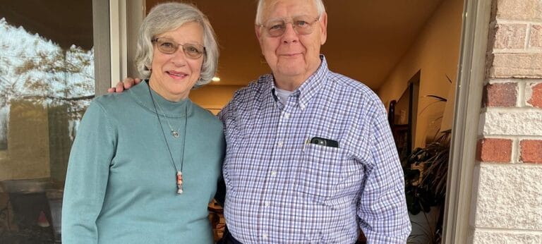 Two residents posing outside a facility entrance