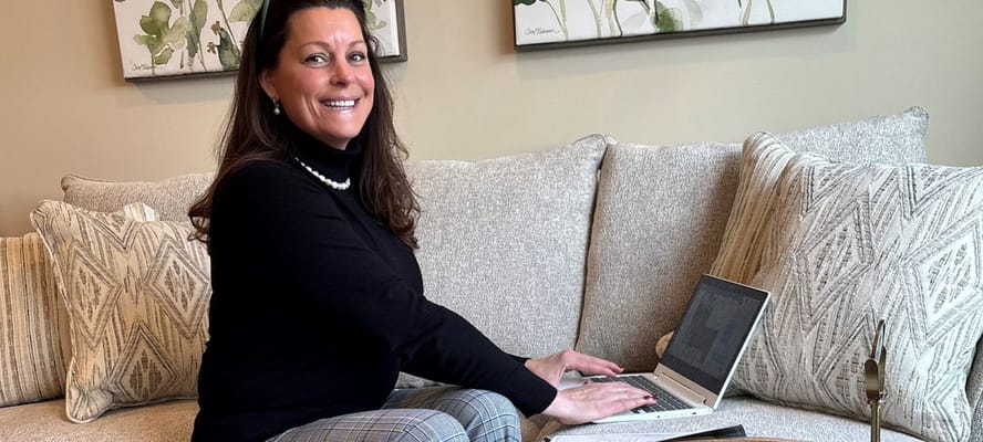 Staff member working on a laptop in a common area