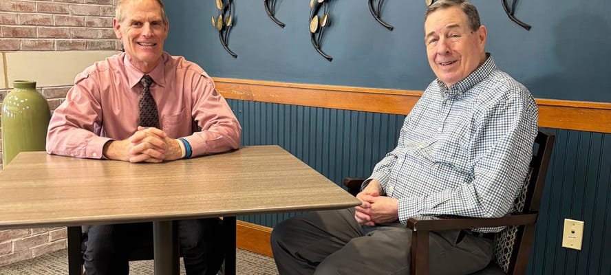 Two men sitting at a table in a communal space