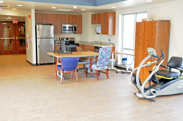 Interior view of a common area with a kitchen and exercise equipment