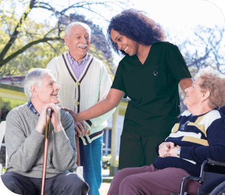 A caregiver interacting with happy residents outdoors