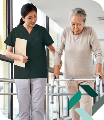 Staff assisting a resident with a walker in a well-lit hallway
