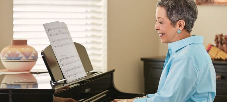 Resident playing piano in a bright room