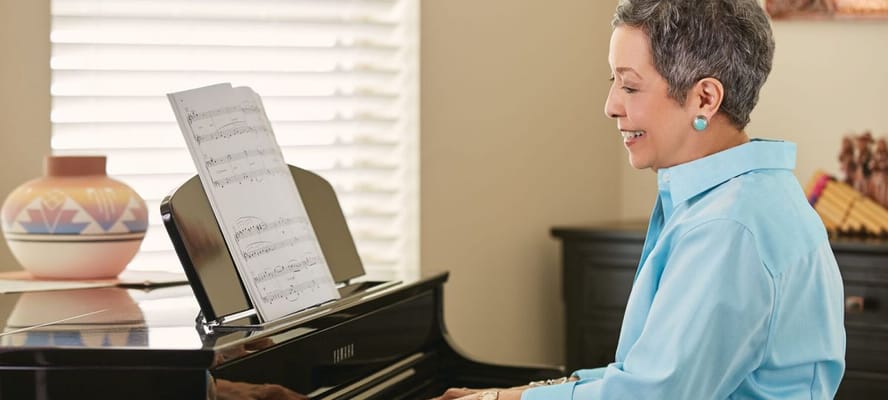 Resident playing piano in a bright room