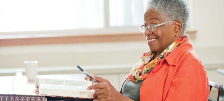 An older woman reading a book with a smile