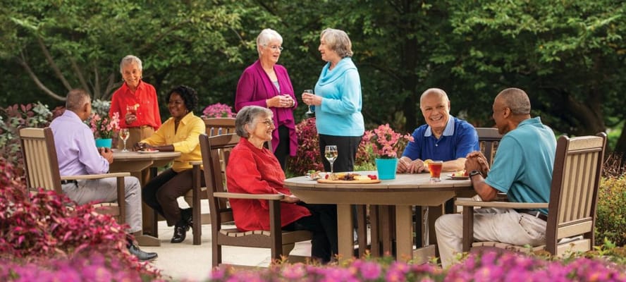 Residents enjoying a meal outdoors in a garden setting