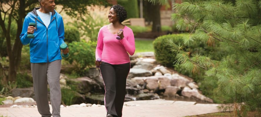 Two residents walking in a garden with weights