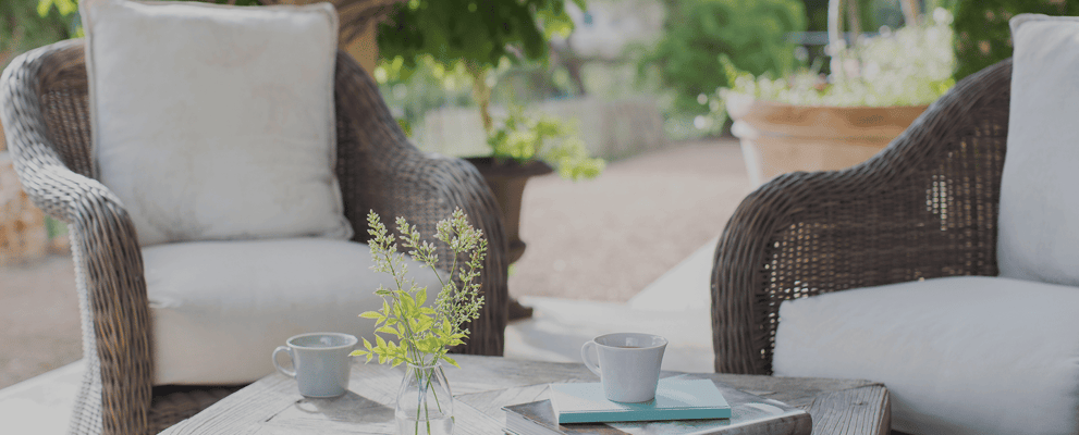 Outdoor seating area with plants and coffee cups