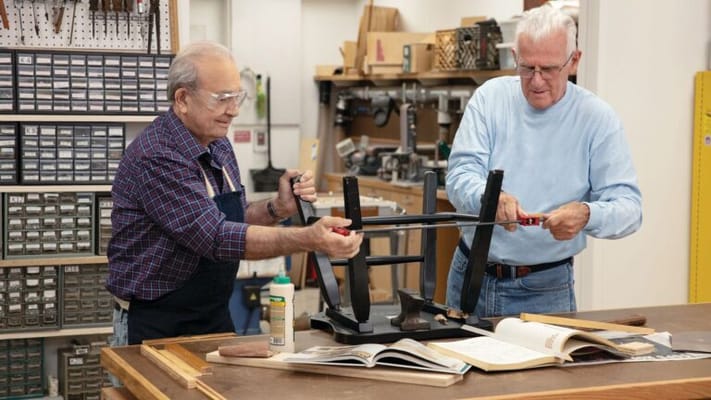 Two residents collaborating on a woodworking project