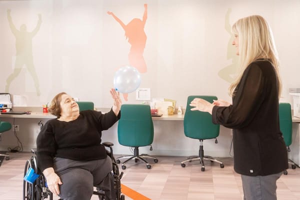 Resident playing with a balloon in an activity room