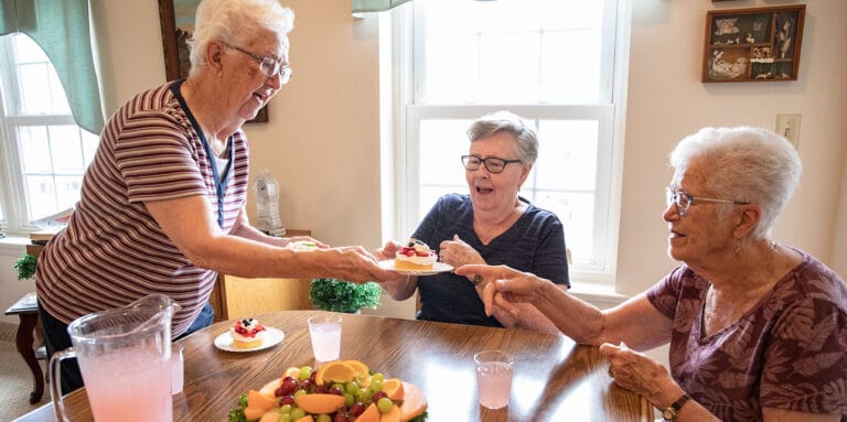 Residents enjoying dessert and drinks at a dining table