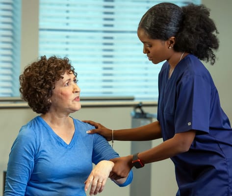 Staff assisting a resident during therapy session