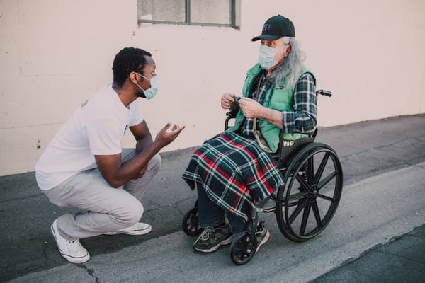 A caregiver talking to a resident in a wheelchair