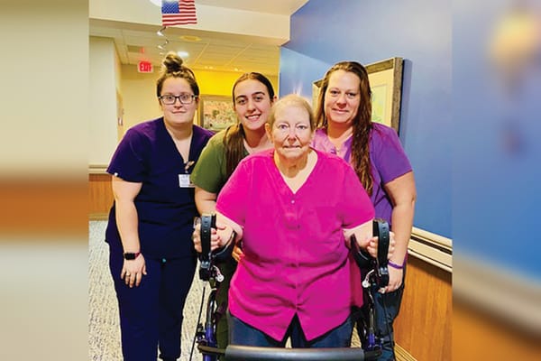 Staff assisting a resident in a hallway