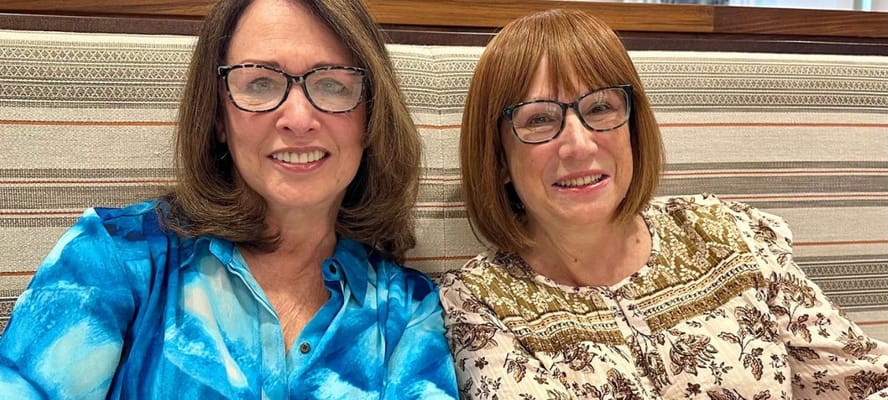 Two smiling women socializing in a comfortable setting