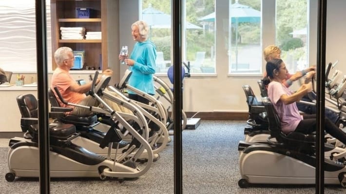 Residents exercising in an indoor fitness area.