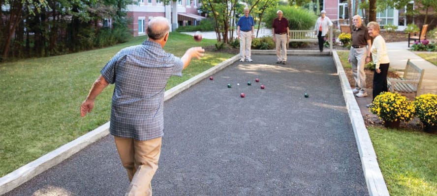 Residents playing bocce ball in an outdoor area