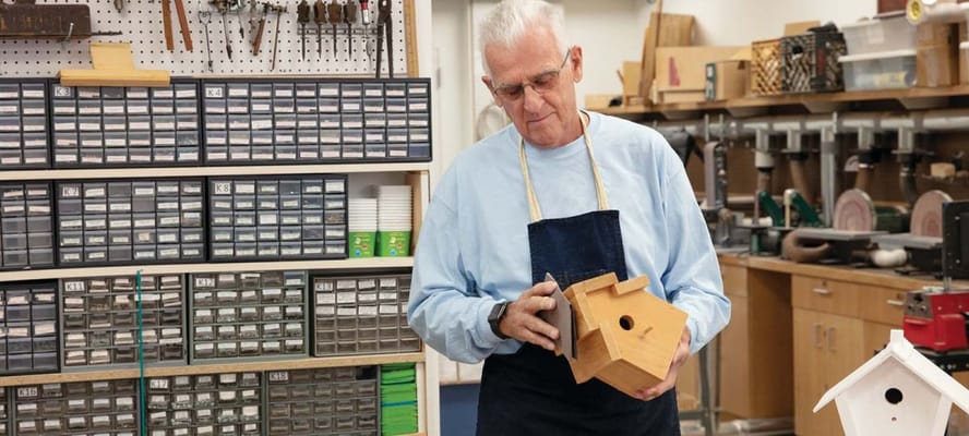 Resident building a birdhouse in a workshop