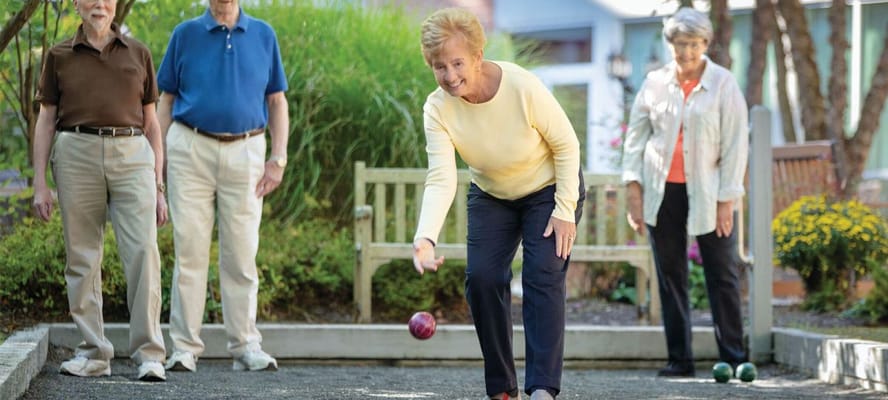 Residents playing bocce ball in an outdoor area