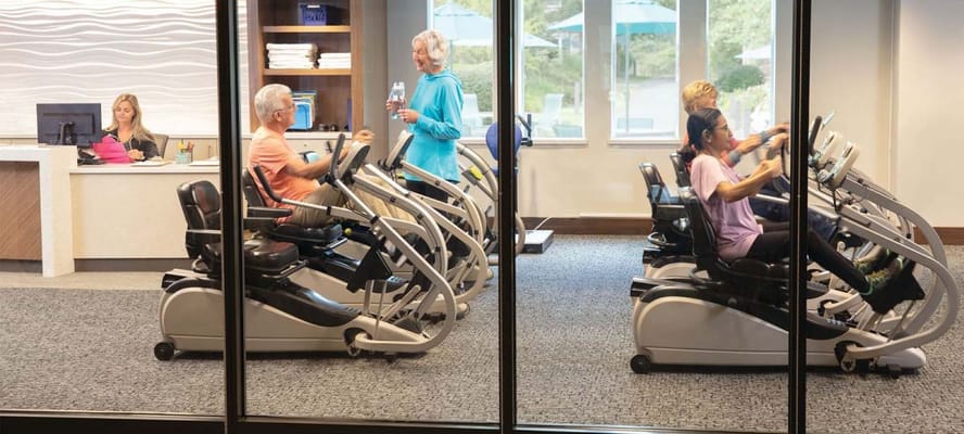 Residents using exercise machines in the fitness area