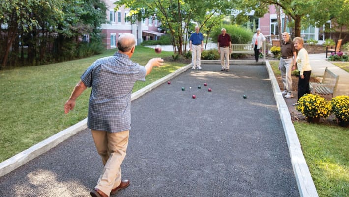 Residents playing bocce ball in a garden area