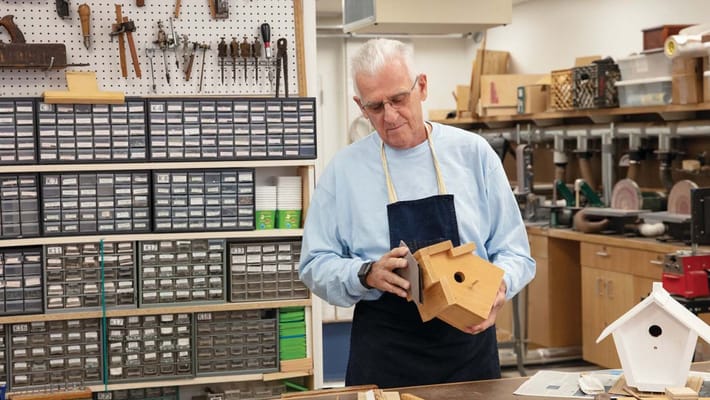Resident working on a birdhouse in a workshop