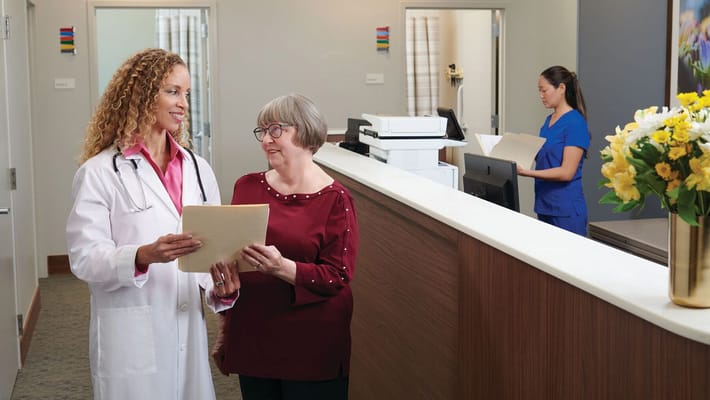 Healthcare staff interacting with a resident in reception.