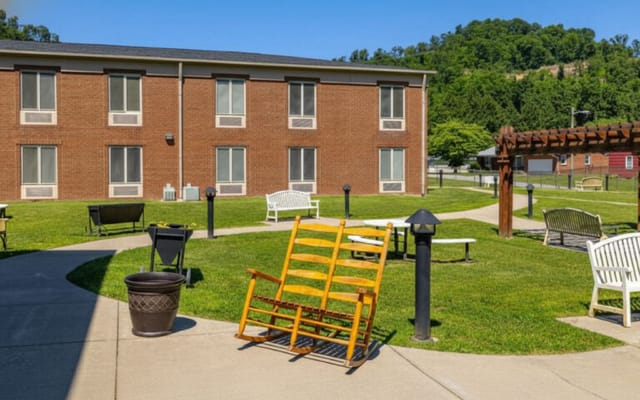 Outdoor seating area with rocking chairs and greenery
