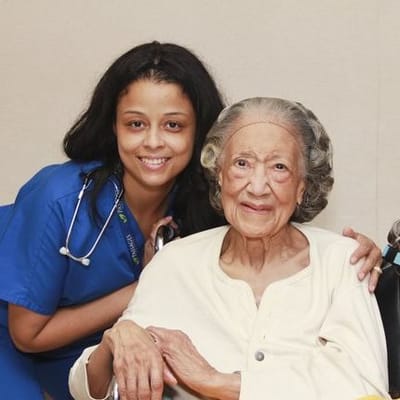 A caregiver smiling with a senior resident